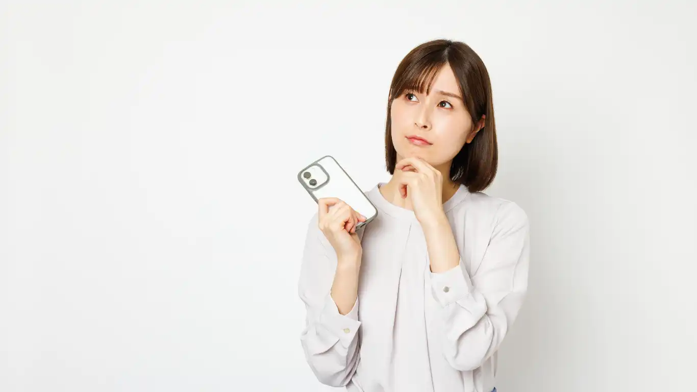 スマホを持って考えている女性