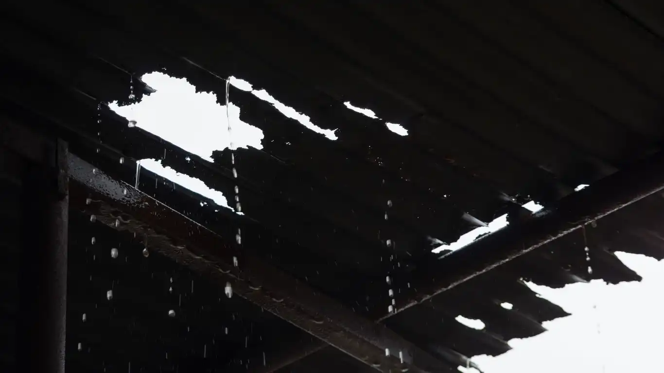 トタン屋根に穴が空いて雨が漏れている様子
