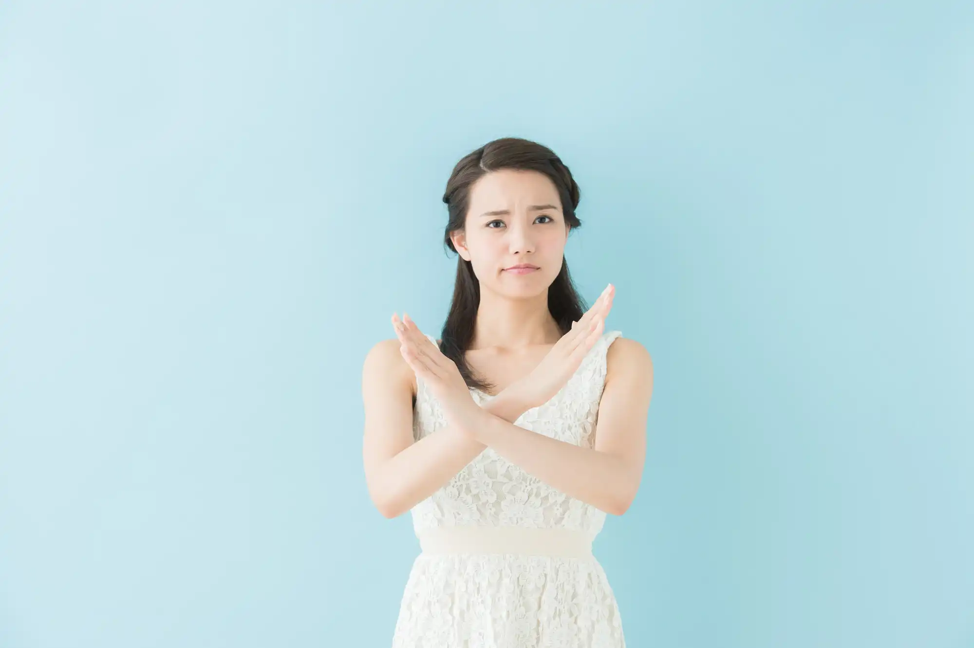 手で罰点をしている女性