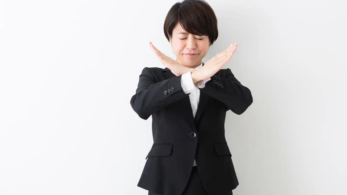 両手でバツ印を作る女性