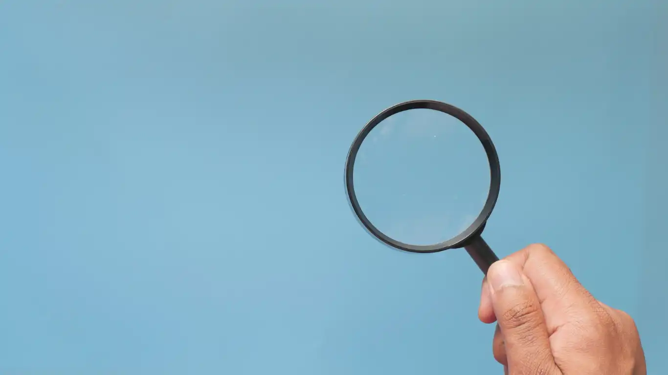 虫眼鏡で青い壁を見ている