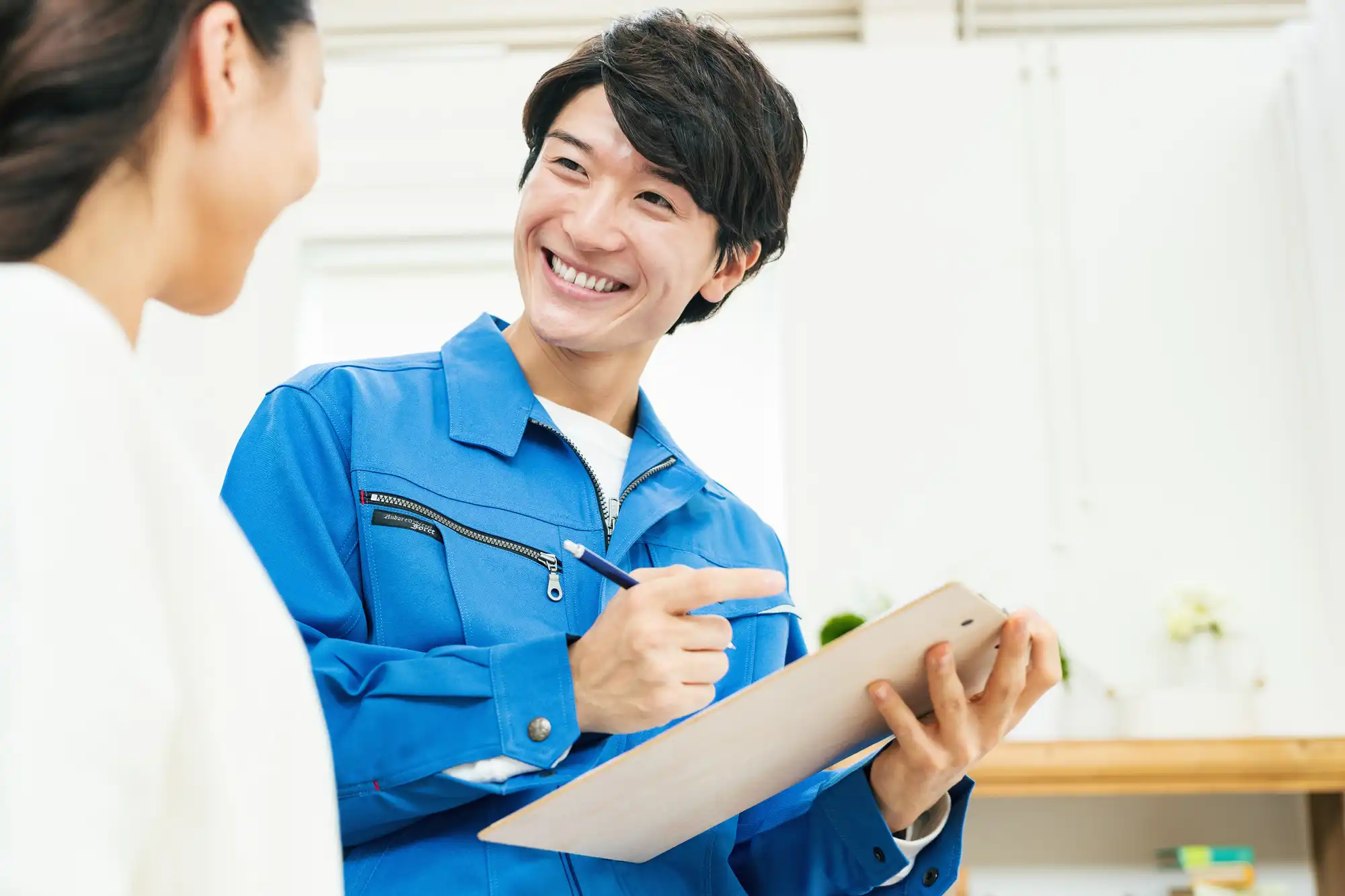 お客さんと話しながら屋根の状態をチェックしている作業員