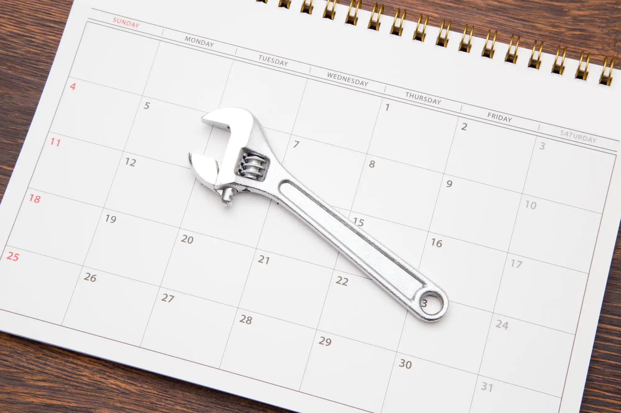カレンダーの上にモンキーレンチを置いている