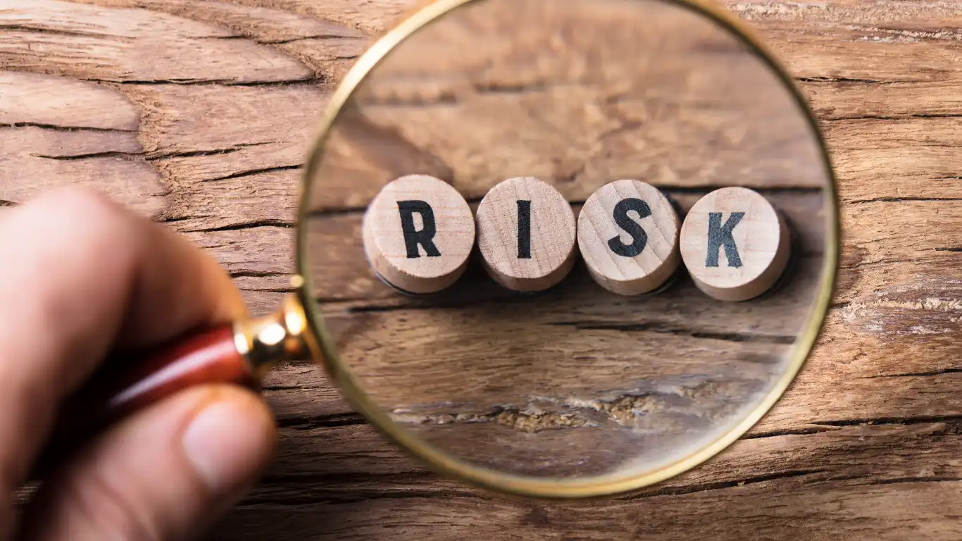 RISKと書かれた小さな丸の木片を虫眼鏡で見ている