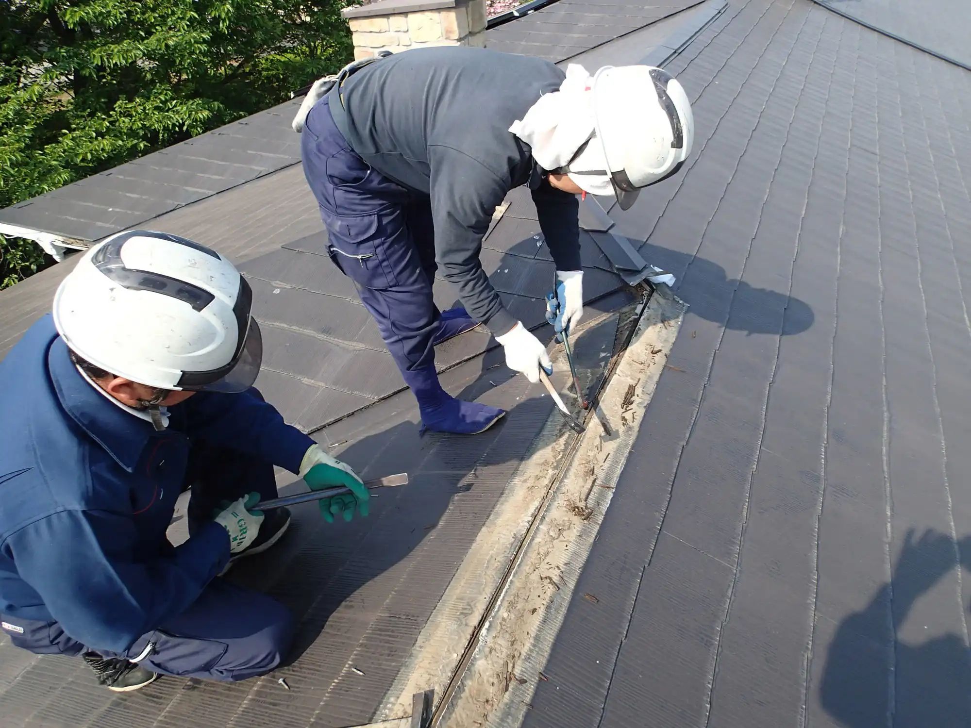 屋根を修理する作業員2人