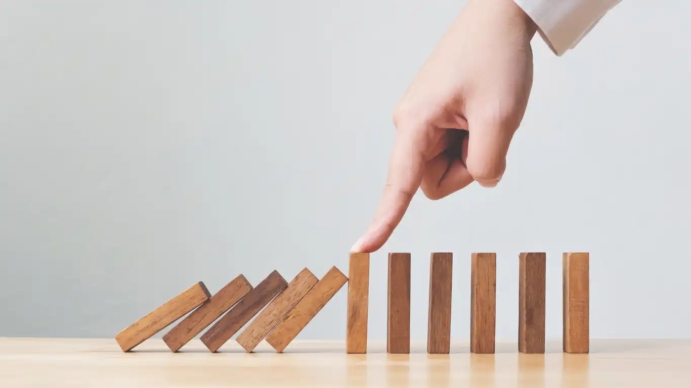 ドミノ倒しを指で止めている